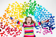 © famveldman - Child playing with rainbow plastic blocks toy