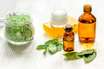 organic cosmetics with herbal extracts of mint on wooden background