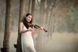 © nengredeye - Young beautiful woman playing violin in the forest.
