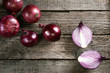 Fresh organic red onions on a wooden background