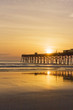 Florida sunrise. Atlantic ocean sunrise in Daytona beach, Florida, USA. Seascape with rising sun over wooden pier.