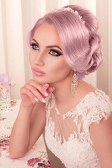 The beautiful woman posing in a wedding dress. Beautiful bride with makeup and hairstyle.