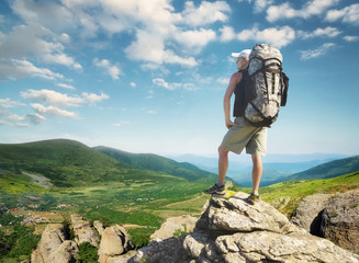 Wall Mural - tourist on the peak of high rocks. sport and active life concept.