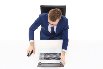 Overhead view of a handsome businessman working in office on a laptop. Business and office concept