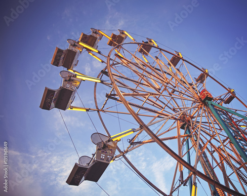 Fotografija  a fair ride during dusk on a warm summer evening toned with a retro filter