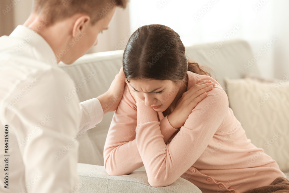 Young depressed woman with boyfriend at home