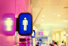 Toilets Icon. Blue Public Restroom Signs With A Male Symbol. Interior Of Airport Terminal.