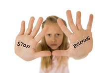 Sweet And Scared Little Schoolgirl Showing The Text Stop Bullying Written In Her Hands