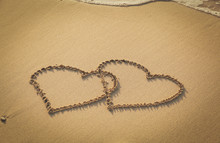 Two Hearts Drawn On Sand Beach