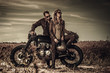 © Nejron Photo - Young, stylish cafe racer couple on vintage custom motorcycles in field