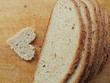 canvas print picture - Heart shaped piece of bread in front of full bread