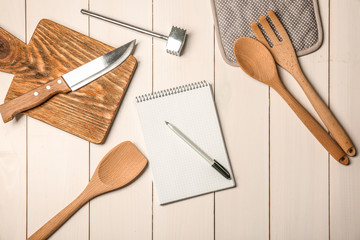 Canvas Print - Kitchen utensils with empty notebook on wooden table