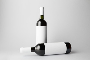 Two wine bottles are standing on gray background