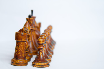 Old chess Board with wooden pieces on a white background.