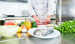 Koch bereitet Zutaten wie Gemüse und Fisch zum Kochen in seiner Küche vor