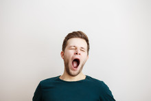 Yawing  Young Man On A Light Background