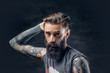 © Fxquadro - Tattooed bearded male in a t shirt.