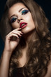 Beautiful girl in Hollywood manner with curls, red lips and blue make-up. Beauty face and hair. Picture taken in the studio