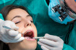 © karelnoppe - Dental surgeon working on female patient.