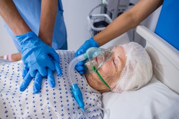 Canvas Print - Doctor and nurse treating senior patient in ward