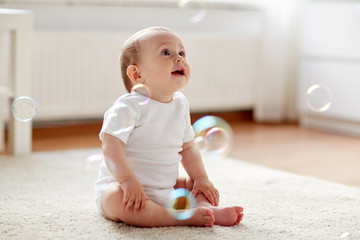 happy baby with soap bubbles at home