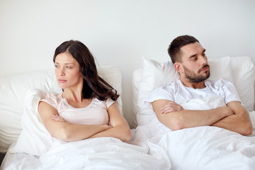 unhappy couple having conflict in bed at home