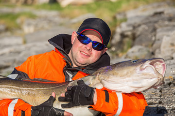 Fisherman in sunglasses holds a big fish