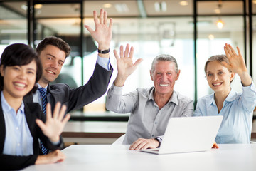 Successful multiethnic team waving at camera