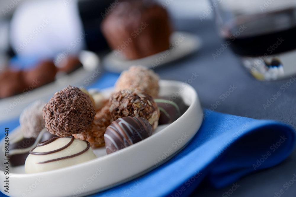 Delicious chocolate sweets and red wine on grey background