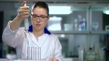 Researcher Working With Dropper In Laboratory. Lab Worker Using Laboratory Equipment. Female Researcher Using Pipette In Lab. Laboratory Woman Filling Test Tubes With Chemical Liquid