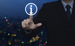© grapestock - Businessman pressing information sign icon over blur colorful night light city tower background