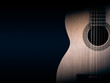 © YB - Part of a orange acoustic guitar on black background.