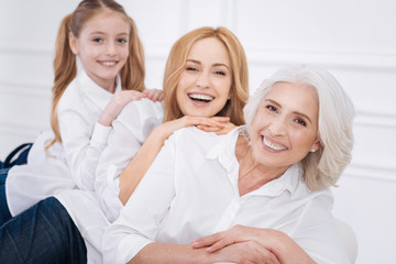 Poster - Cheerful family members sitting on the couch