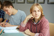© pressmaster - Pensive guy looking aside while sitting by desk at lesson