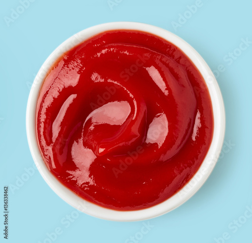 Fotomural Bowl of ketchup on blue background, from above