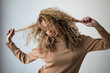 © GAM Studios - Young woman tugging on her curly hair