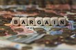 bargain - cube with letters, money sector terms - sign with wooden cubes