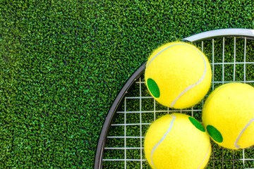 Wall Mural - tennis racket on green background top view