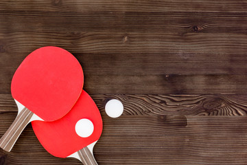 Wall Mural - Red racket for ping pong ball wooden background top view