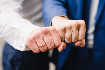 hands of two men with wedding gold rings