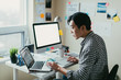 © ZeroThree - Asian man working at a comptuer