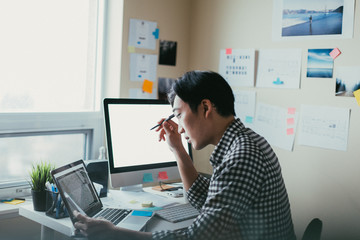 Canvas Print - Asian man working at a comptuer