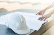 © lersan - The white safety helmet with the man verify blueprint for his pr