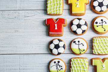 Poster - Delicious gingerbread cookies decorated with football signs on white wooden background