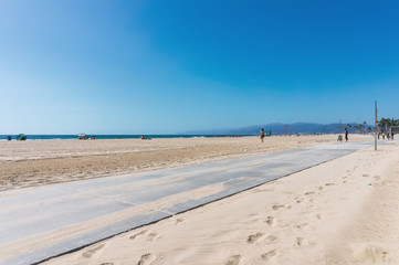 Empty beach with roller road near the sand. Clear sky in sunny weather in California