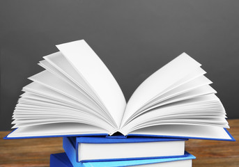 Sticker - Pile of books on wooden table and grey background