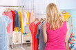 © Africa Studio - Young woman looking clothes on rack at showroom