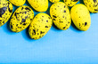Yellow easter eggs on blue wooden background