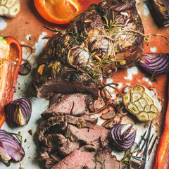 Wall Mural - Cooked Roastbeef meat with roasted vegetables and herbs in metal baking tray, top view, selective focus. Slow food concept