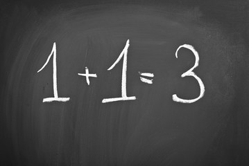 example of 1 + 1 = 3 on a blackboard with chalk